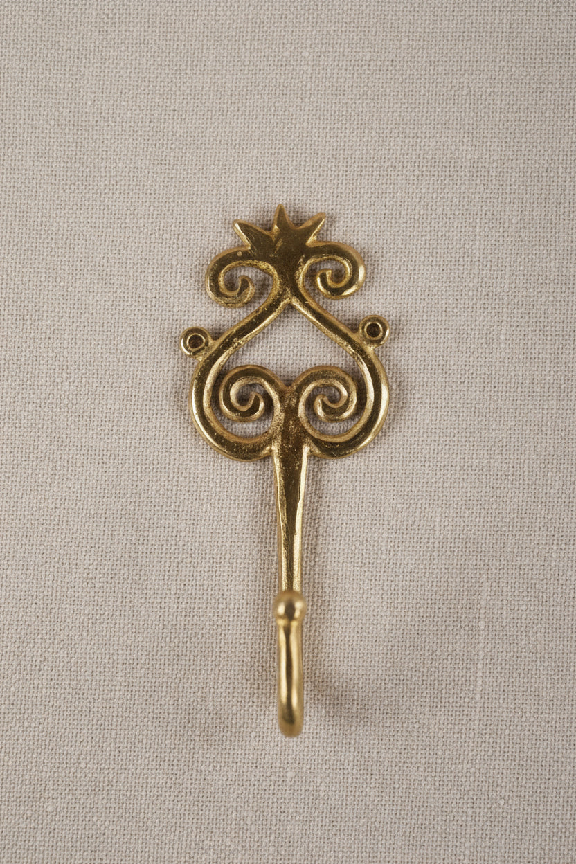 Brass decorative hook on a white background