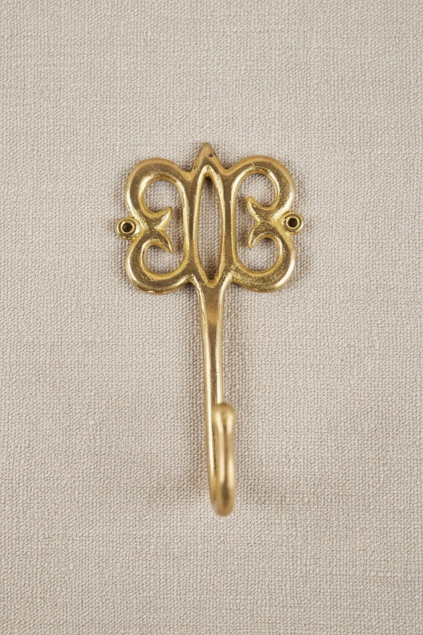 Brass decorative hook on a white background