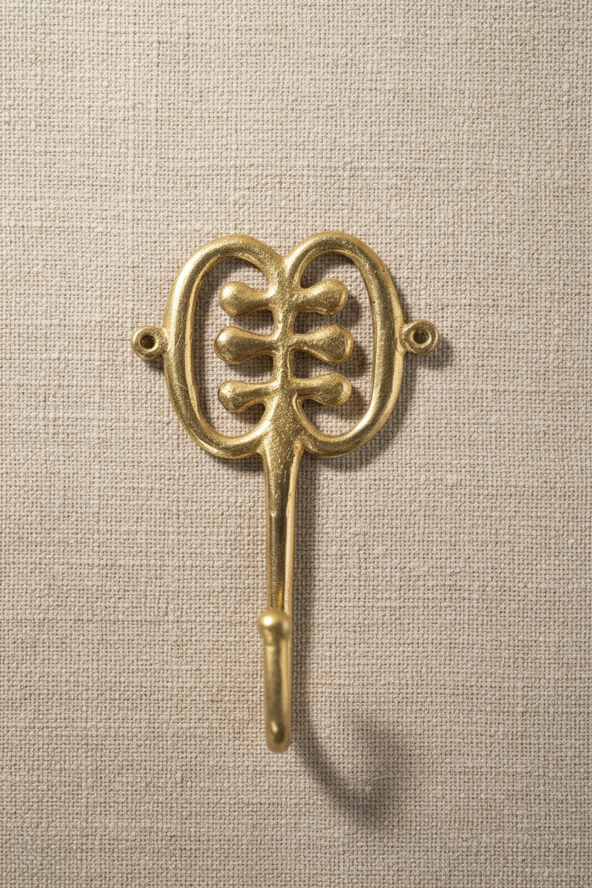 Brass decorative hook on a linen background