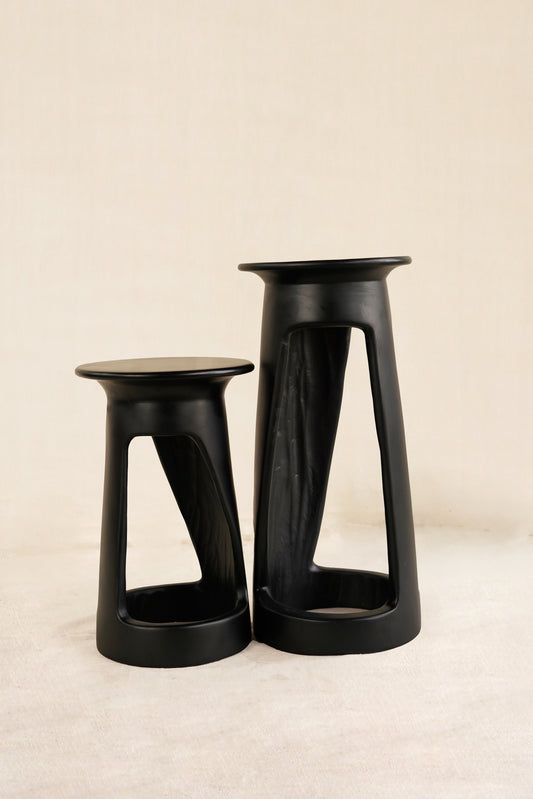Two black stools on a beige background