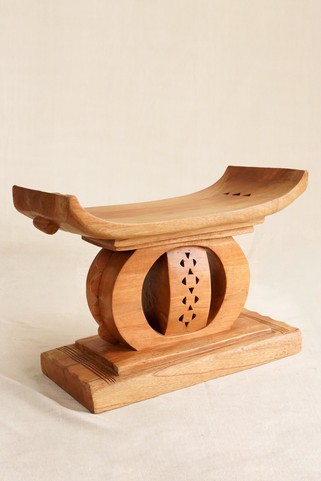 Wooden stool with a decorative design on a beige background