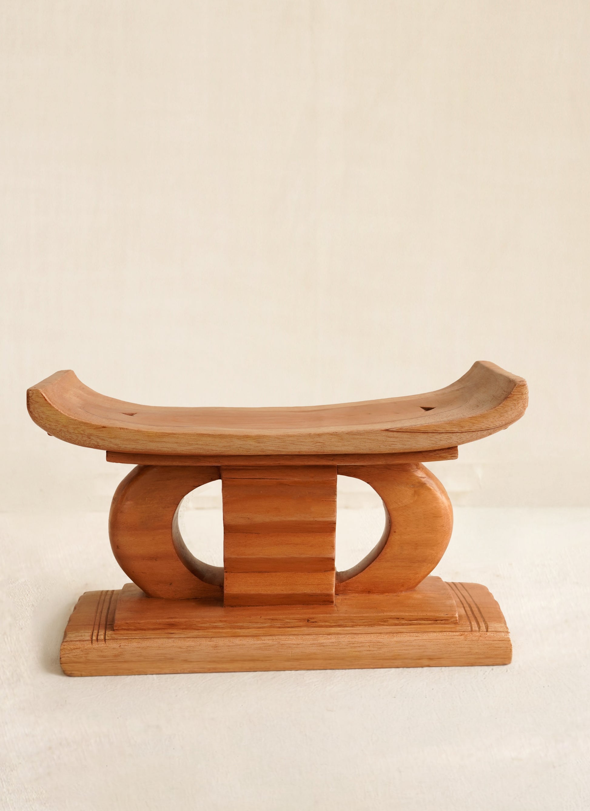 Miniature Wooden Ashanti  stool on a beige background