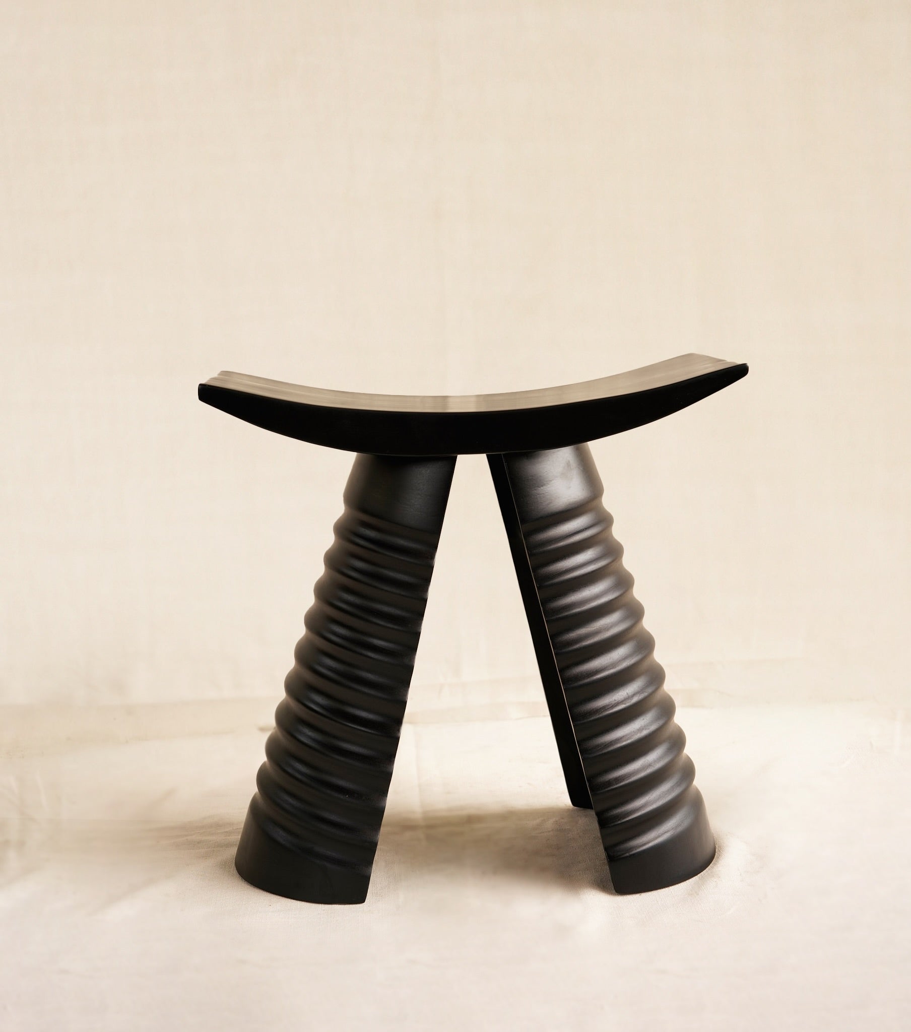 Black stool with unique design on a beige background
