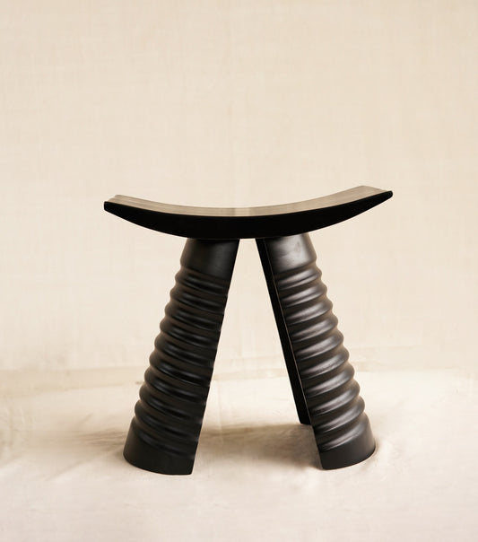 Black stool with unique design on a beige background