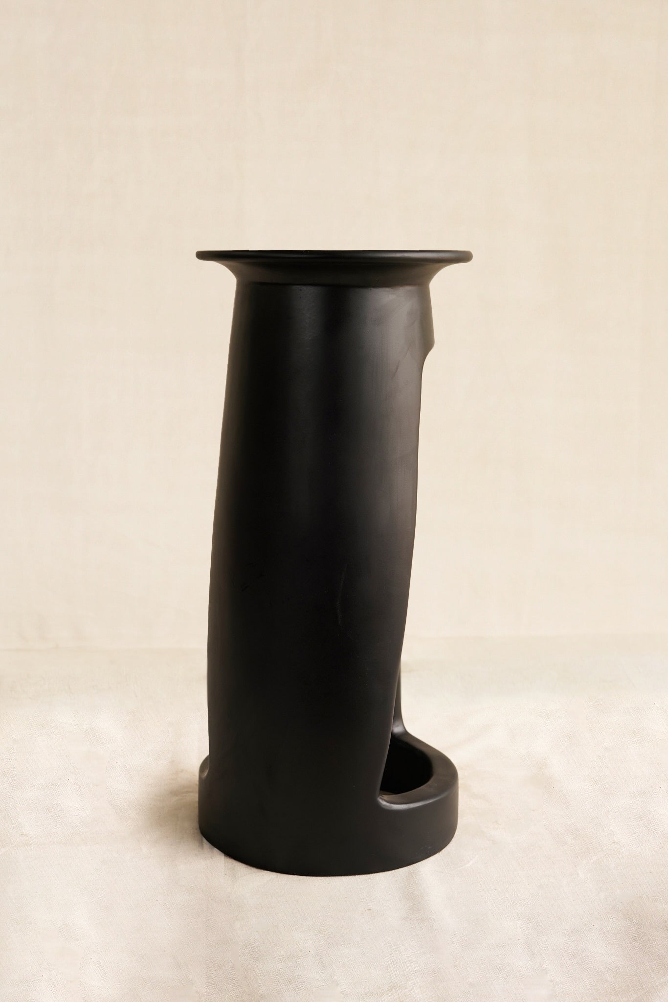 Black cylindrical table  on a beige background
