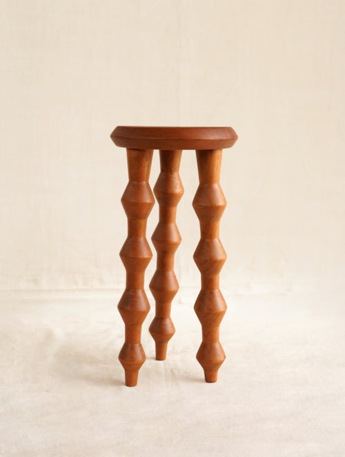Wooden stool with spiral legs on a beige background