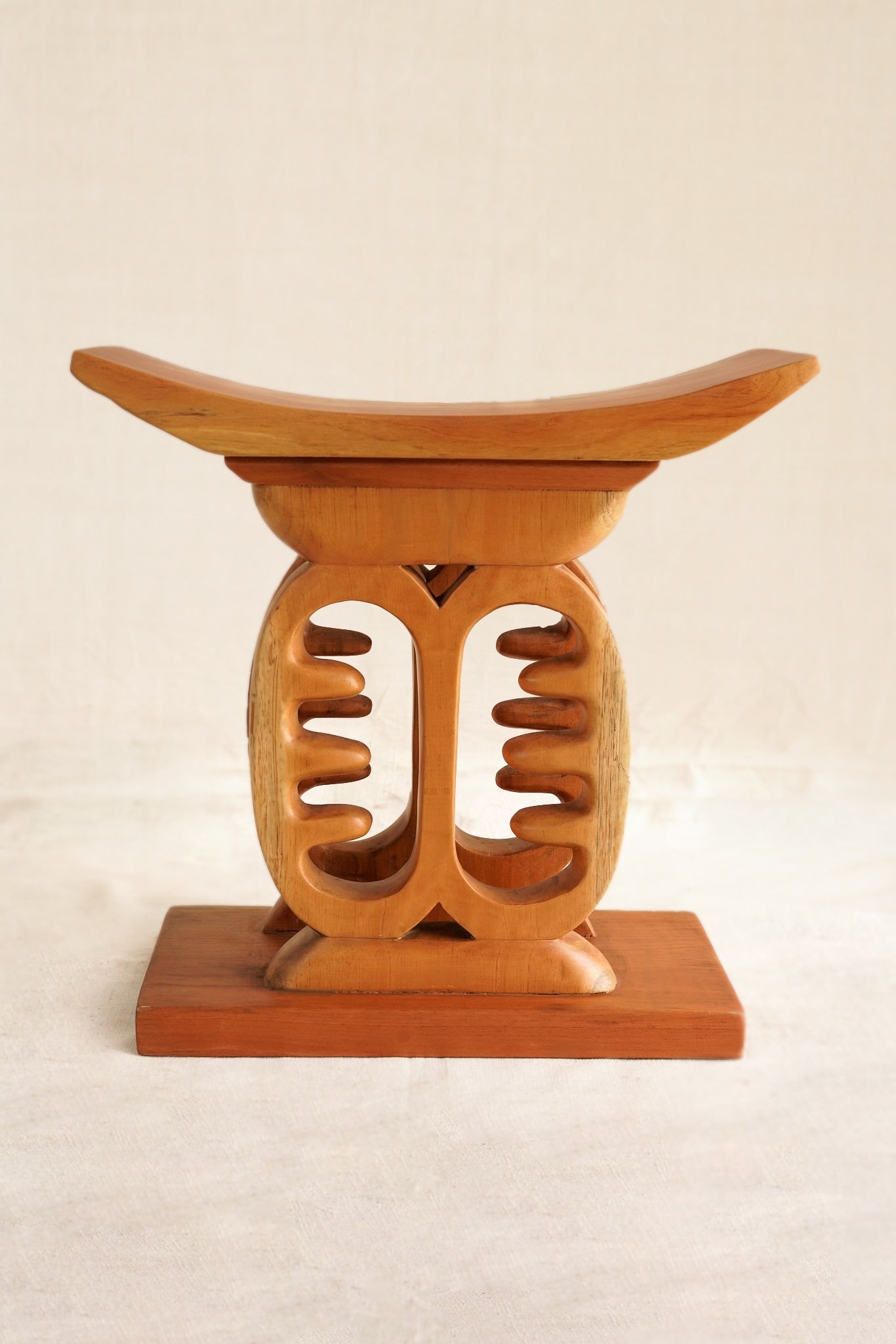Wooden Ashanti stool with a unique design on a beige background
