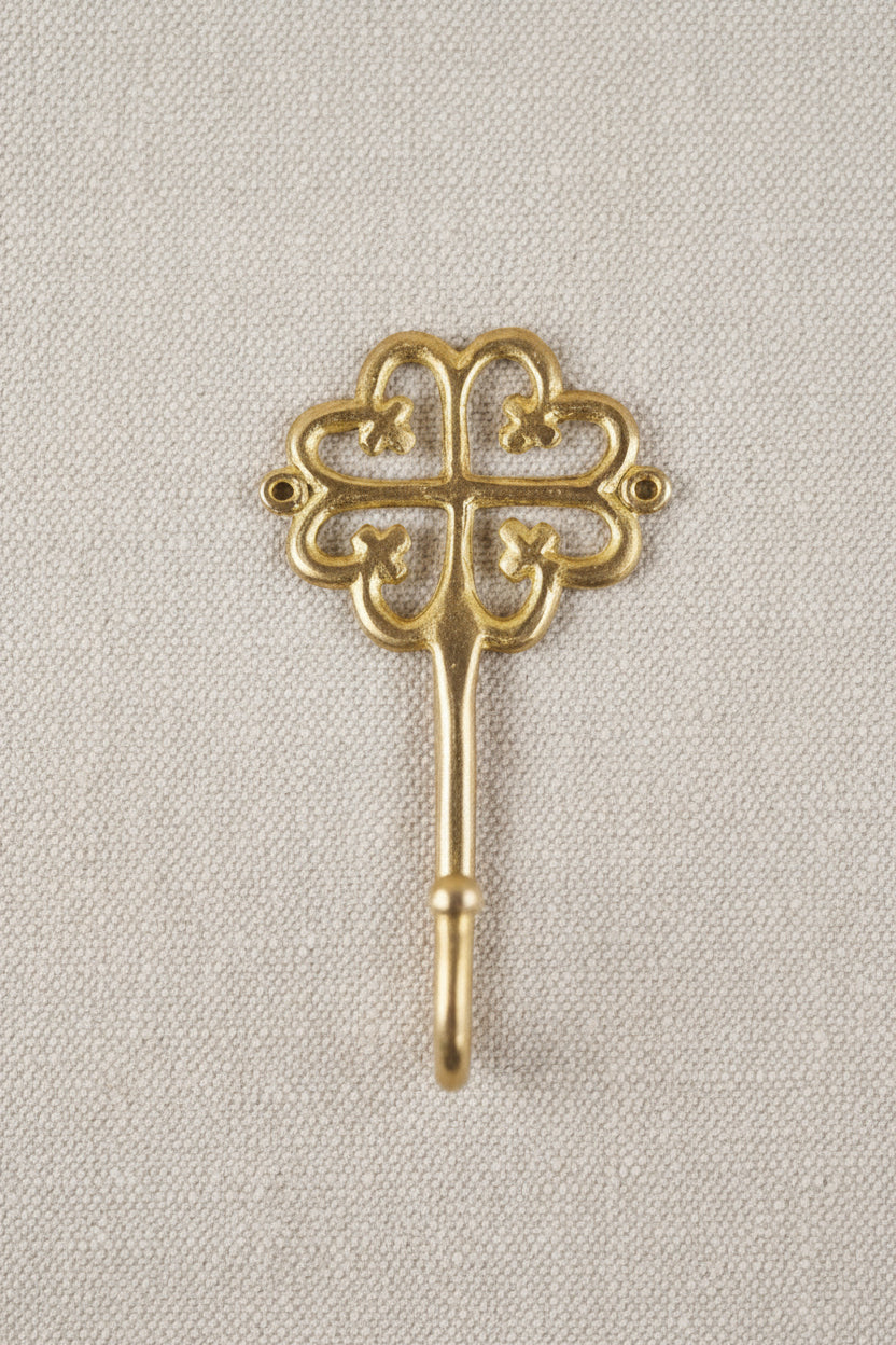 Brass decorative hook on a white background