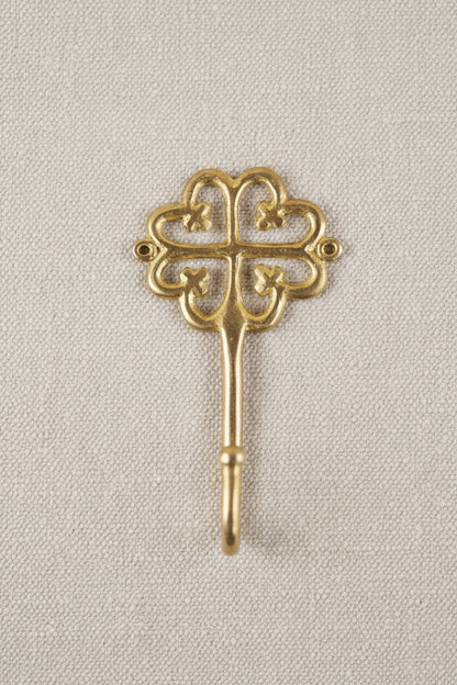 Brass decorative hook on a white background