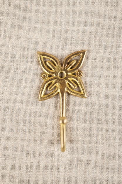 Brass decorative hook on a linen background