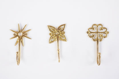 Set of brass decorative hooks on a white background