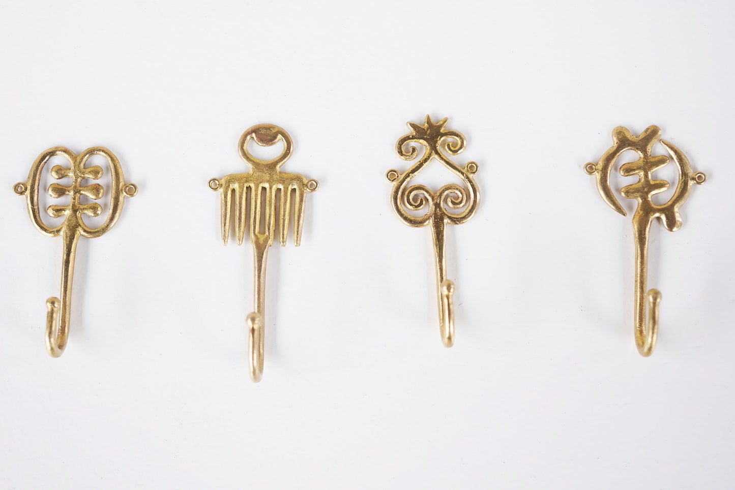 Set of brass decorative hooks on a white background