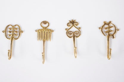 Set of brass decorative hooks on a white background