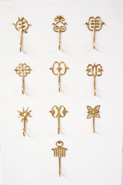 Set of brass decorative hooks on a white background