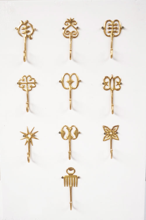Set of brass decorative hooks on a white background