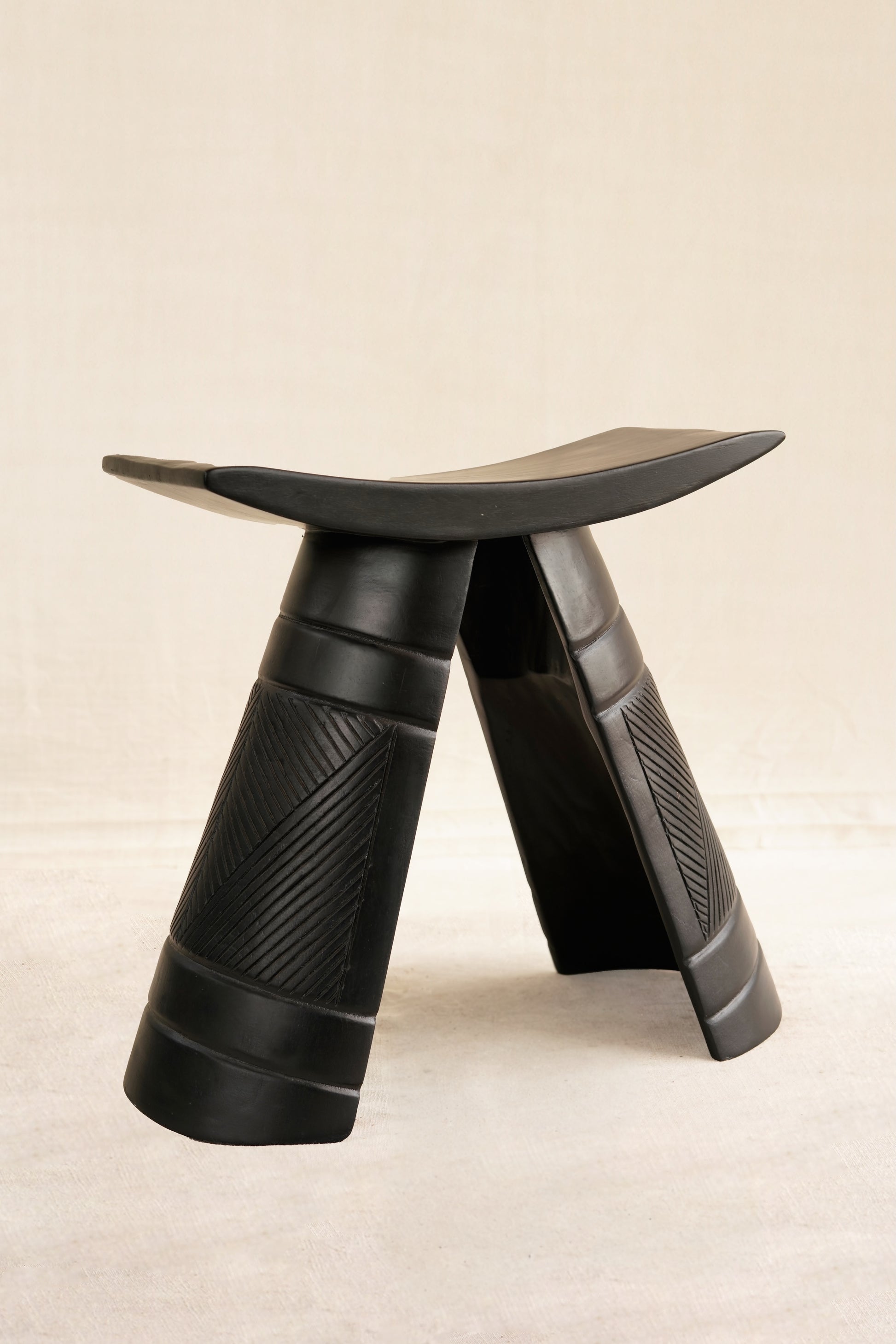 Black stool with a unique design on a beige background