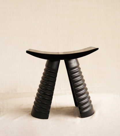 Black stool with unique design on a beige background