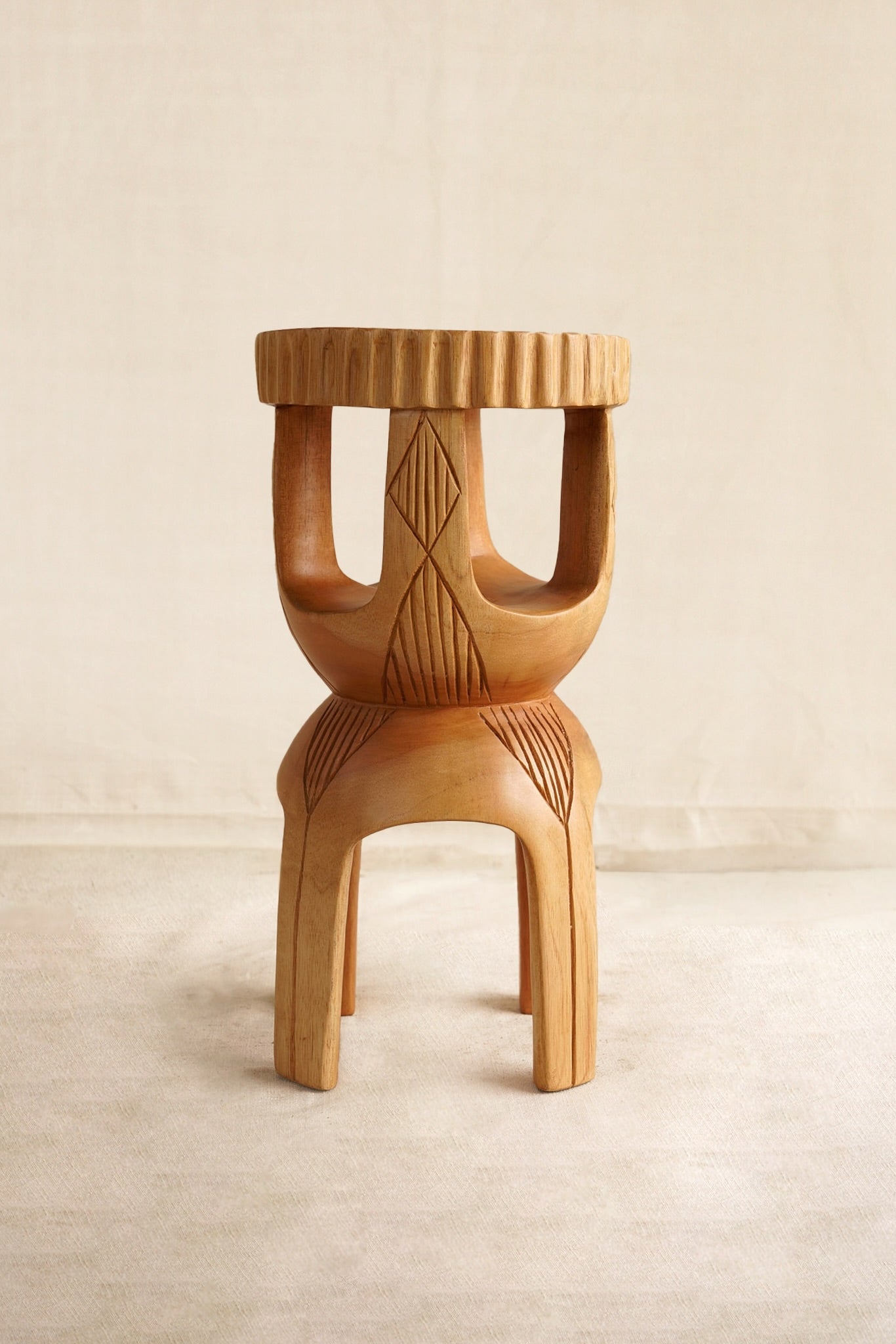 Wooden stool with geometric patterns on a beige background
