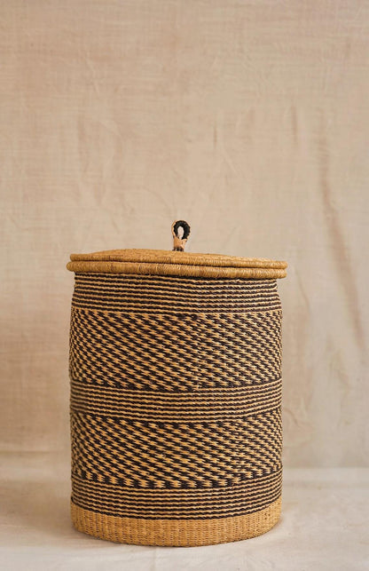 Woven basket with a lid on a neutral background